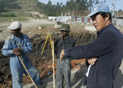 A Chinese construction worker (R) supervises the building of a road on 30 April 2007 in Makenisa, 9km south of Addis Ababa, Ethiopia. (Simon Maina/AFP)