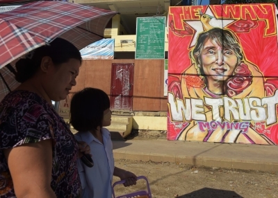 People walk past a graffiti depiction of Myanmar's opposition leader Aung San Suu Kyi outside the headquarters of the National League for Democracy party (NLD) in Yangon, Myanmar on November 13, 2015. (Nicolas Asfouri/Getty Images)
