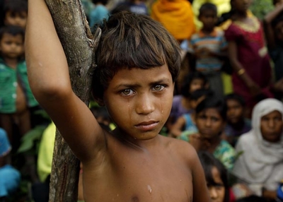 A Rohingya refugee girl looks on at newly arrived refugees who fled to Bangladesh from Myanmar on September 6, 2017. (K M ASAD/AFP/Getty)