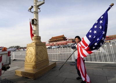 A worker holds a U.S. flag on Tiananmen Square