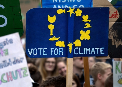 Demonstrators hold up a poster reading "Vote for Climate" in the design of the EU flag 