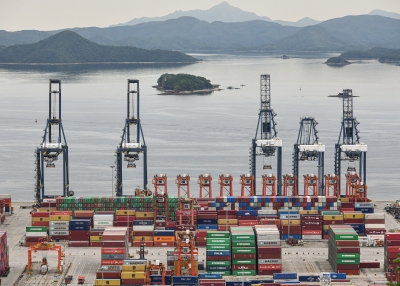 Aerial photo of cargo containers stacked at a port.