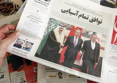 A man in Tehran holds a local newspaper reporting on its front page the China-brokered deal between Iran and Saudi Arabia to restore ties, signed in Beijing the previous day, on March, 11 2023.
