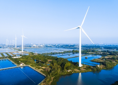 Aerial view of wind turbines and fish ponds at daytime.