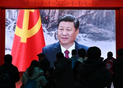 People watch a video featuring Chinese President Xi Jinping at the Military Museum in Beijing on March 3, 2024.