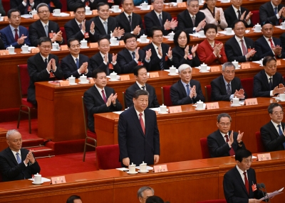 China's President Xi Jinping is applauded by Premier Li Qiang, Politburo Standing Committee member Cai Qi 