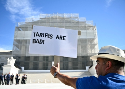 A demonstrator holds up a sign reading "Tariffs are bad" outside the US Supreme Court in Washington, DC.