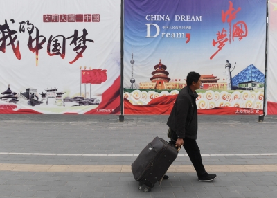 A man walks past billboards promoting the "China Dream"