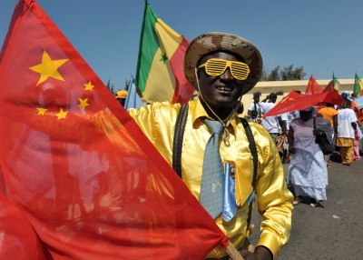 A Senegalese man waves a Chinese flag
