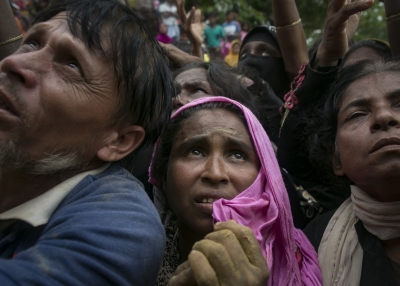 Refugees look up as they scramble for donations in the Balukhali camp on September 18, 2017 in Cox's Bazar, Bangladesh. Nearly 400,000 Rohingya refugees have fled into Bangladesh since late August during the outbreak of violence in the Rakhine state. (Allison Joyce / Getty Images)